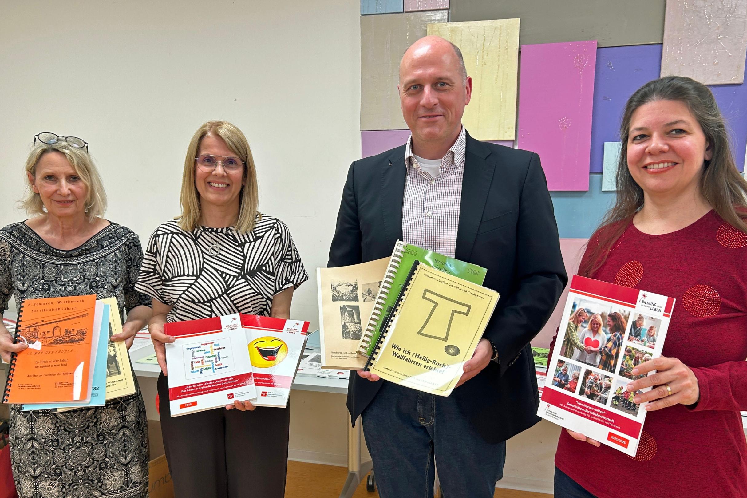 Anne Schuler, Clementina Gattone (KEB Saar-Hochwald), Thomas Berenz (Leiter der KEB im Bistum Trier) und Isabell Valentin (Schreibwerkstatt Bous) präsentieren die Aufsatzbände der vergangenen Jahre