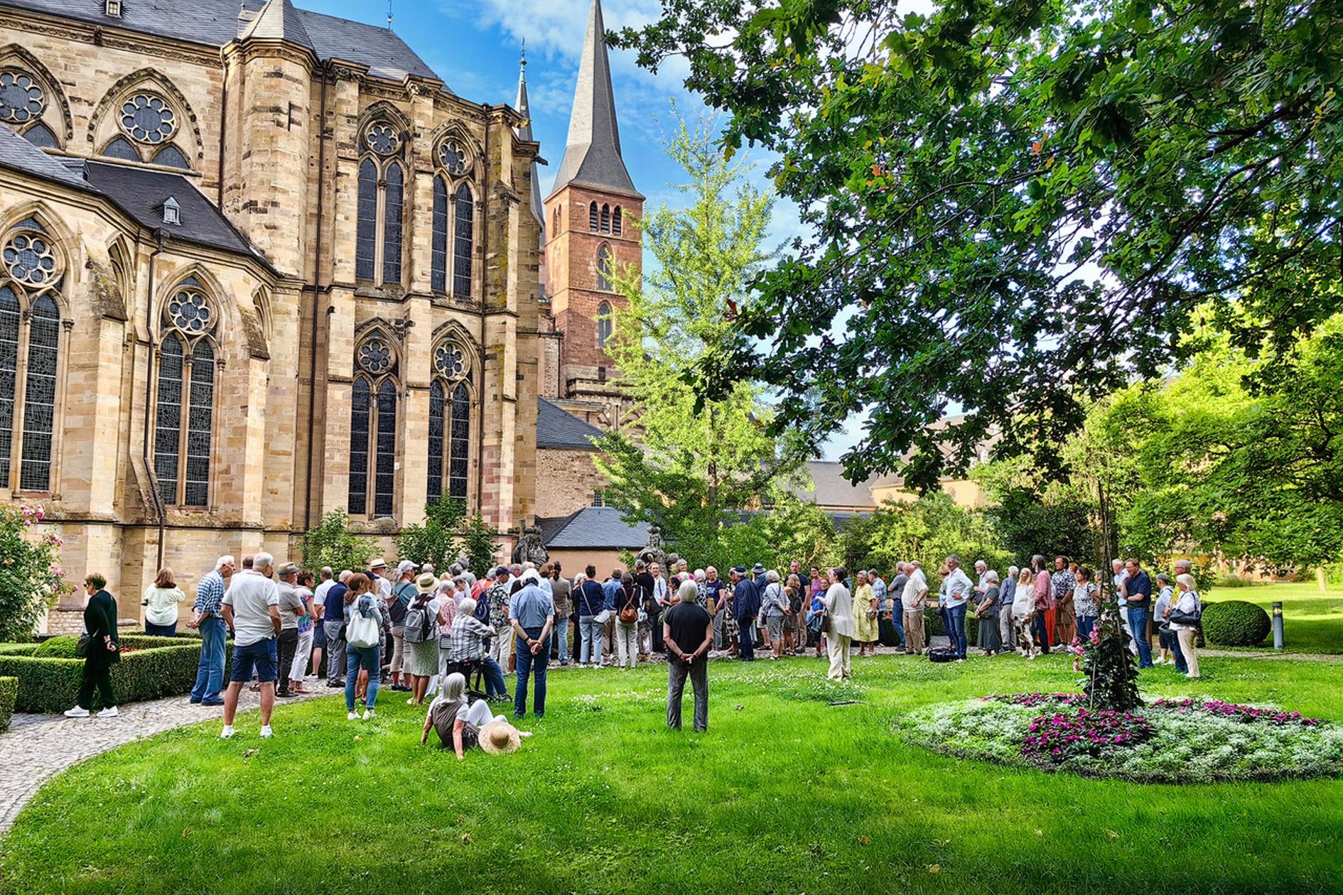 Im Bischofsgarten, mit dem Trierer Dom im Hintergrund, stehen die Teilnehmer des TheoTalks